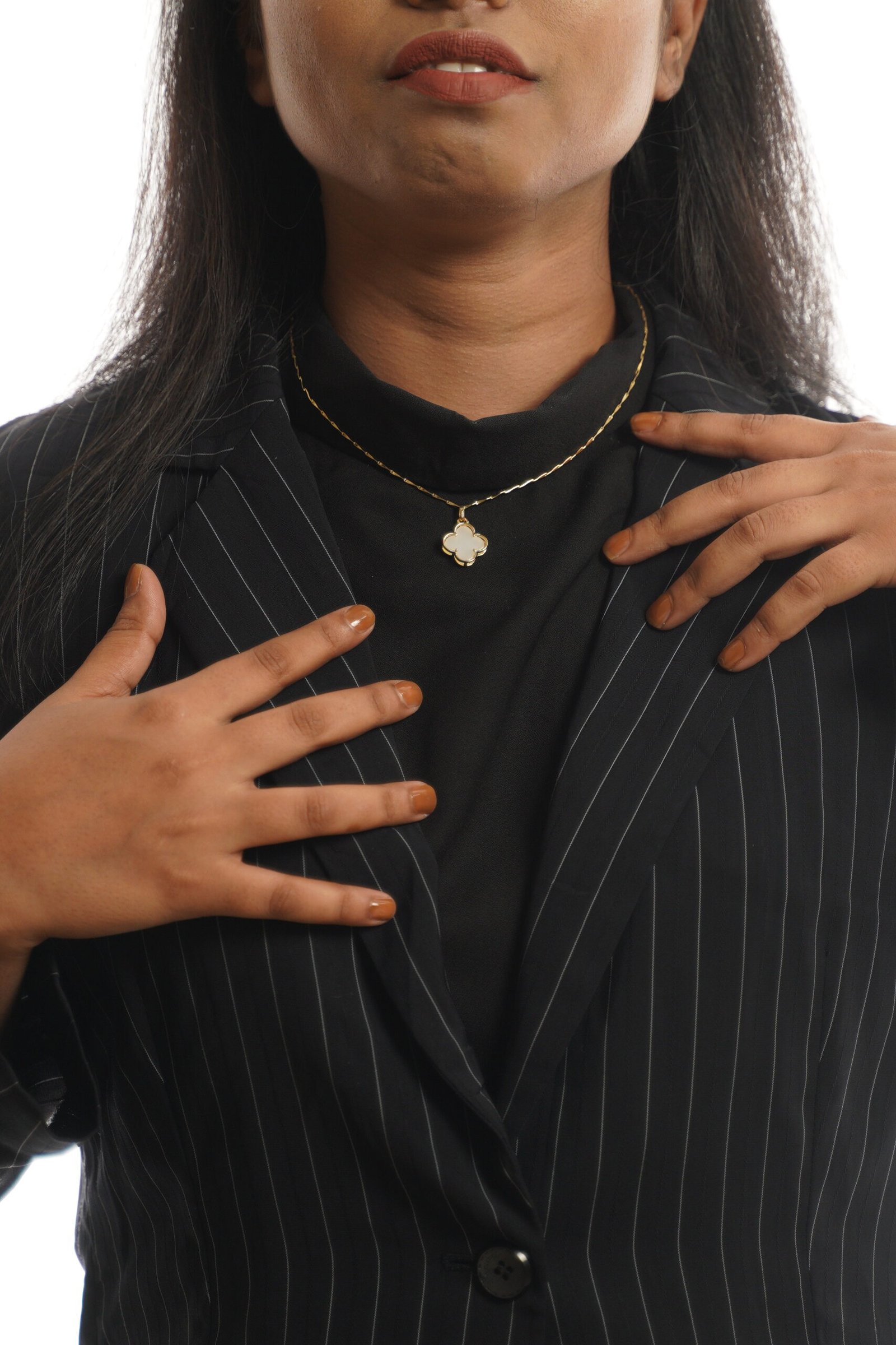 Elegant ivory clover pendant necklace on a woman with black attire.