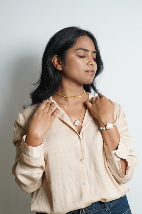 Elegant layered jewelry with baroque pearls and gold accents.