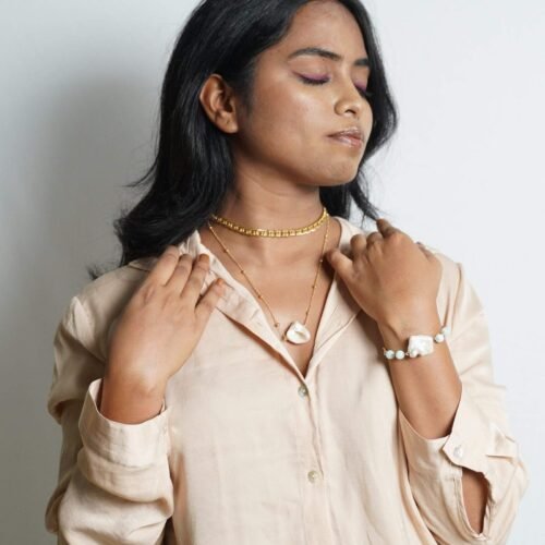 Elegant layered jewelry with baroque pearls and gold accents.