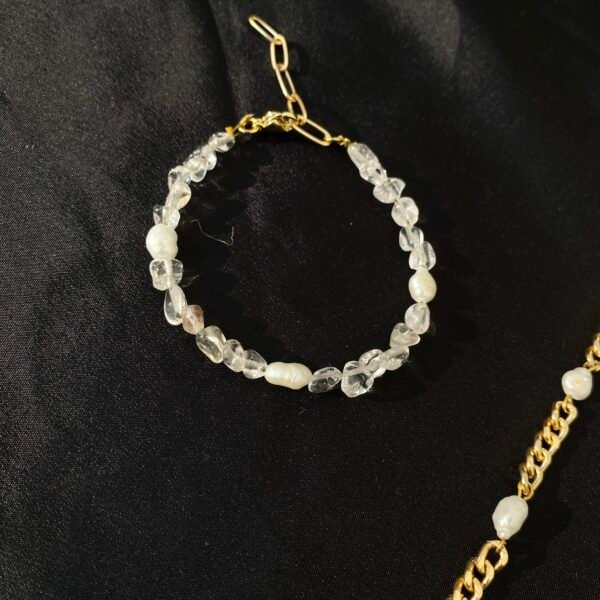 Pearl and crystal stone pearl bracelet with gold chain detail.